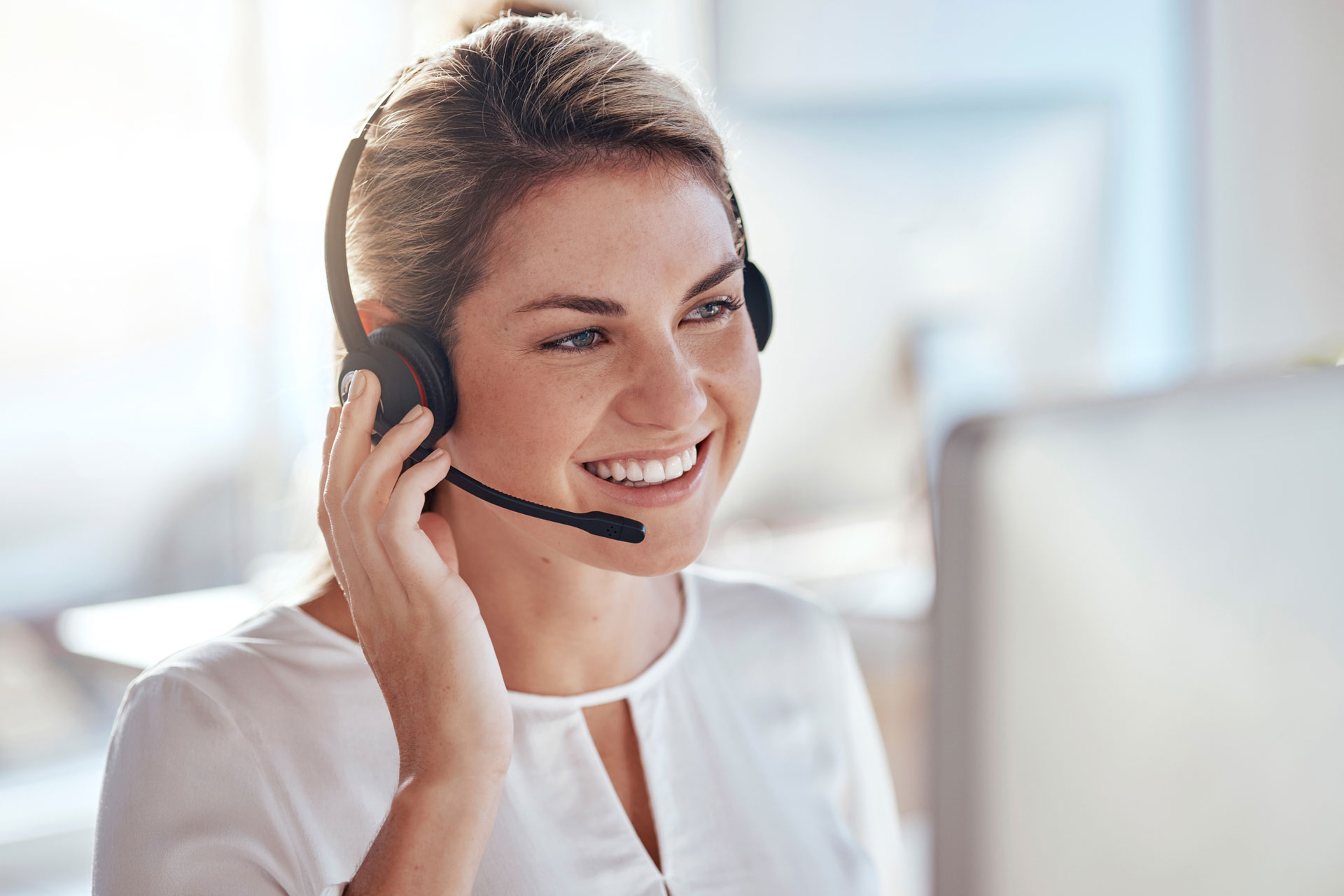 Eine Frau trägt ein Headset mit Mikrofon – Symbolmotiv für telefonische Beratung und die Kontaktaufnahme mit dem Jobcenter.