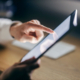 Eine Person bedient mit dem Finger ein Tablet – Symbolmotiv für die Nutzung digitaler Angebote und Online-Services des Jobcenters.