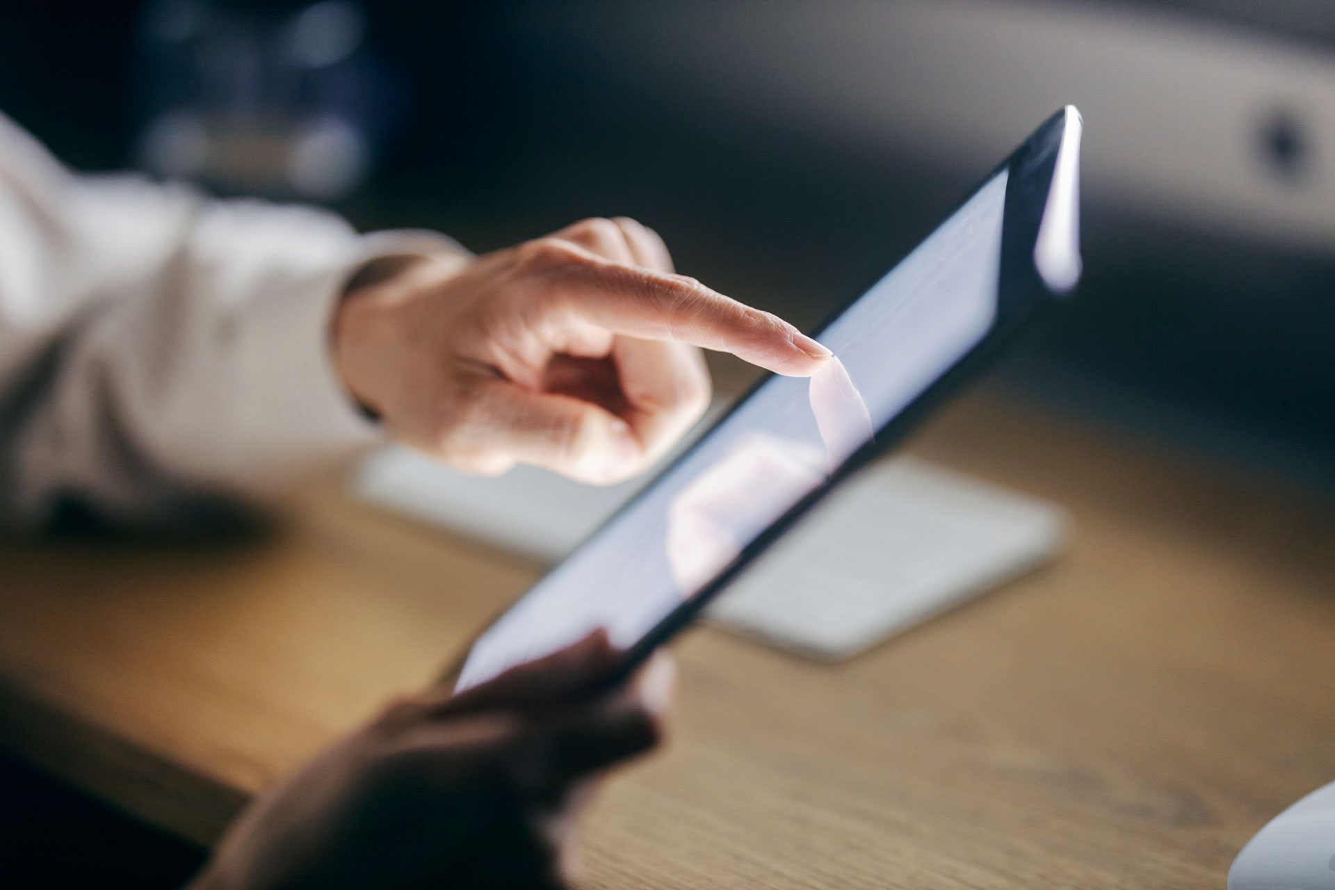 Eine Person bedient mit dem Finger ein Tablet – Symbolmotiv für die Nutzung digitaler Angebote und Online-Services des Jobcenters.